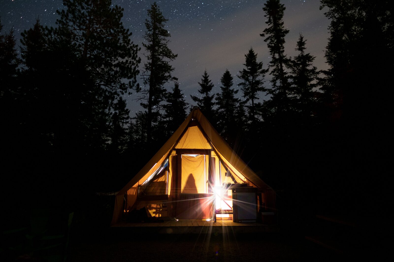 Tenda glamping illuminata di notte nel bosco