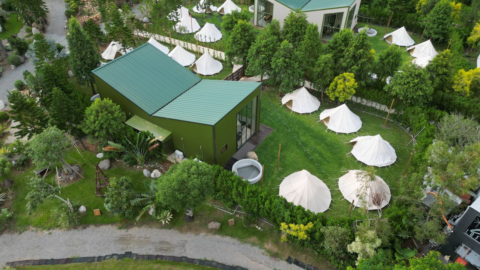 Aerial view of a glamping resort with multiple dome tents surrounded by greenery